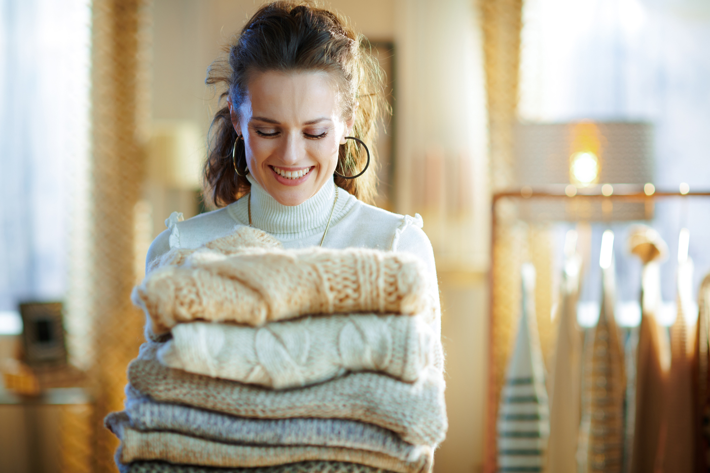 woman holding sweaters
